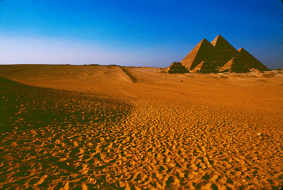 Hot desert sands with Pyramids in the background.