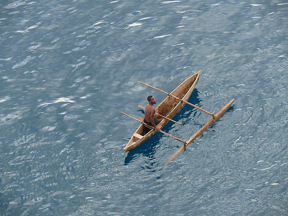Man in outrigger canoe.