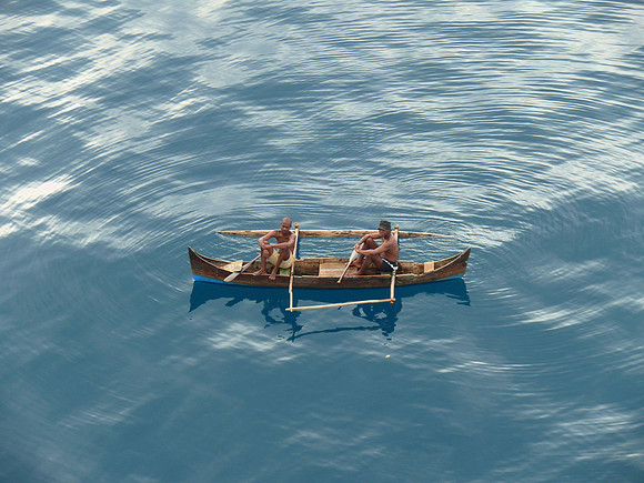 Two men rest in canoe.