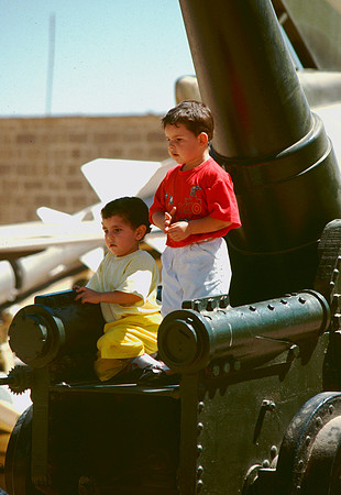 Two young boys play on cannon